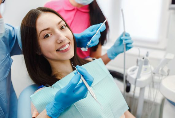 A denist doing a teeth whitening procedure on a child patient.
